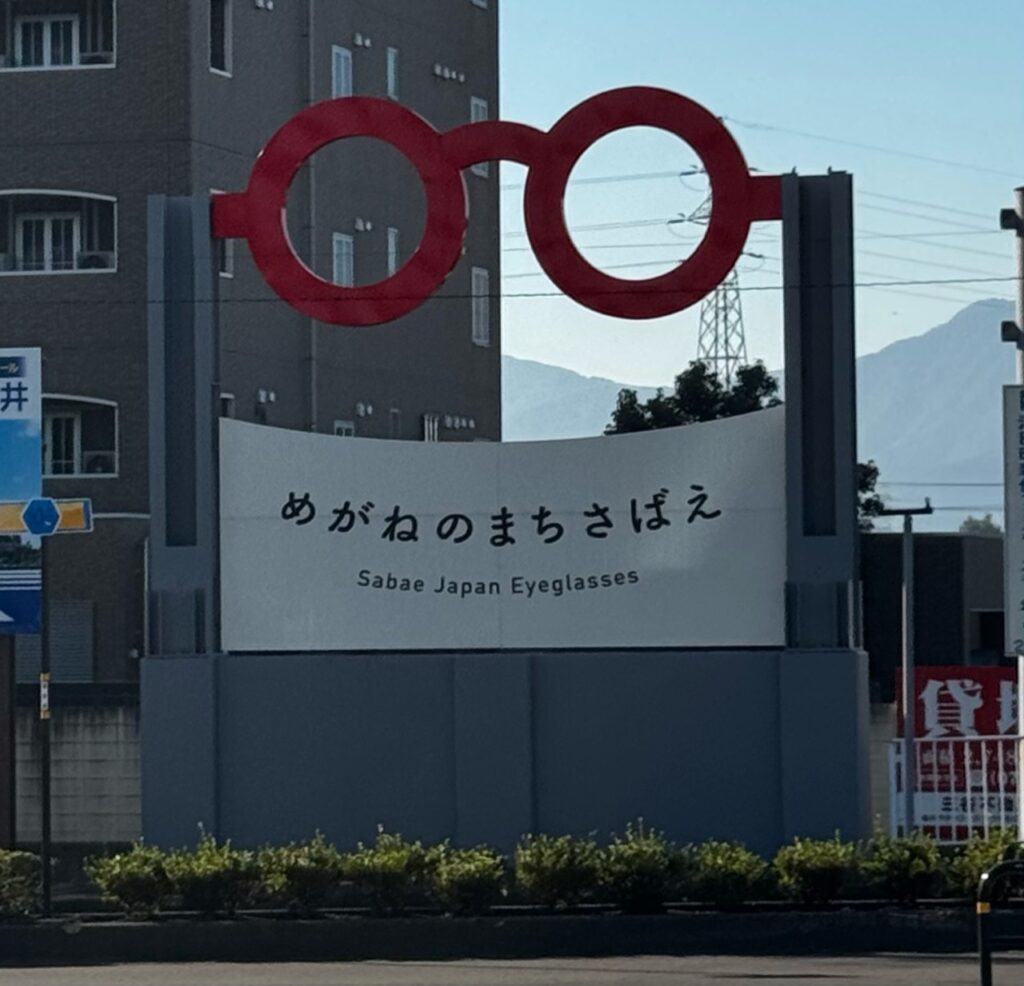 福井県鯖江市の赤い眼鏡のモニュメントと「めがねのまちさばえ」の看板